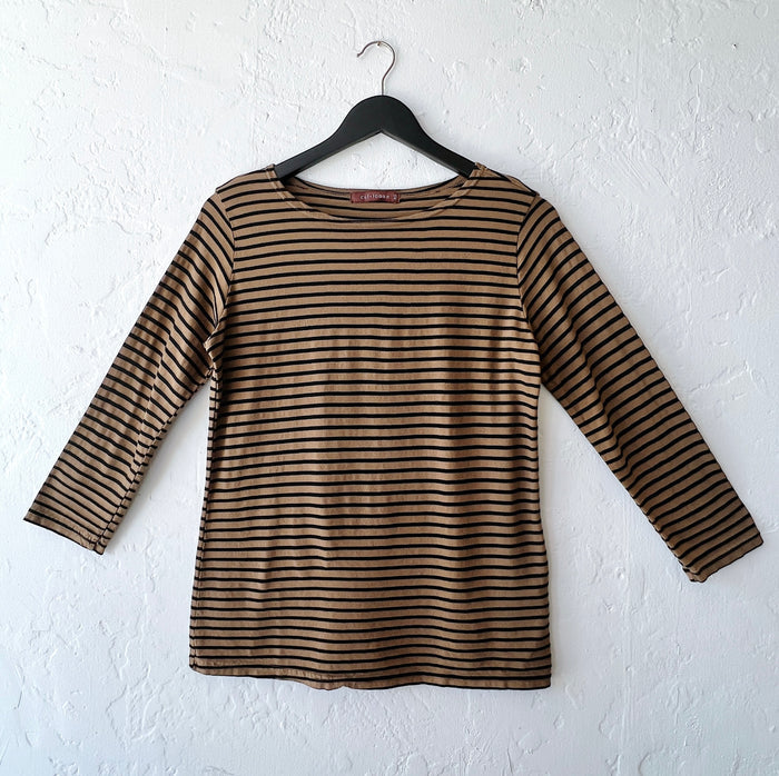 Brown and black striped long-sleeve shirt on a hanger against a white wall