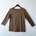 Brown and black striped long-sleeve shirt on a hanger against a white wall