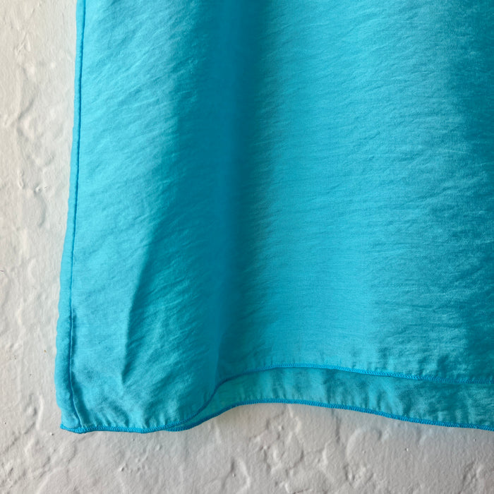 Close-up of a blue fabric corner on a textured white background