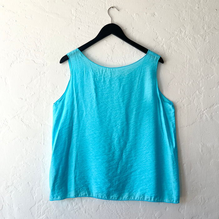 Blue tank top on a hanger against a white wall