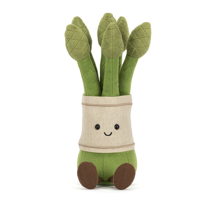 Jellycat Amuseables Asparagus plush toy — a bunch of five green asparagus stalks with quilted tips, wrapped in a cream linen band with an embroidered smiling face and black bead eyes, with brown corduroy feet, front-facing on a white background