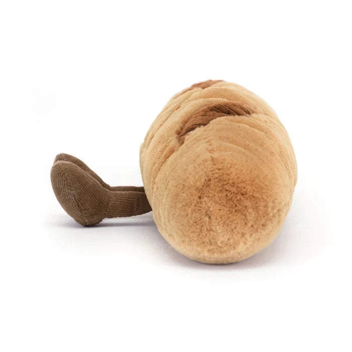 Jellycat Amuseables Baguette — end-on view of the plush baguette showing the rounded crusty end, corduroy score marks along the top, and one small brown corduroy foot, on a white background