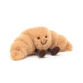 Plush toy croissant with a smiling face on a white background