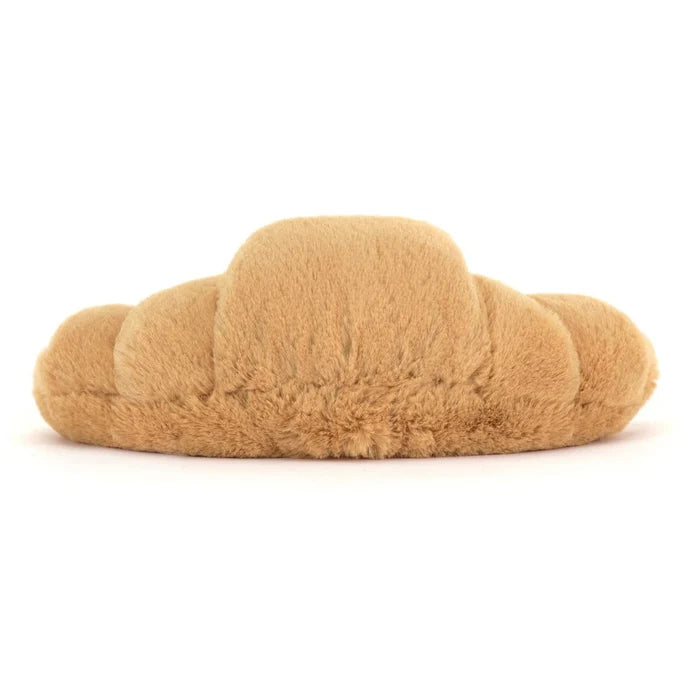 Plush toy croissant on a white background as seen from behind