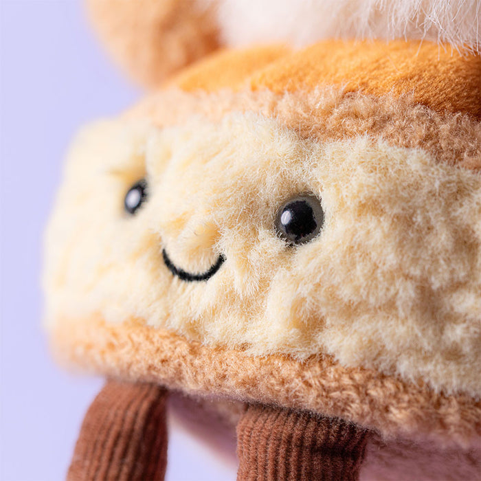 Close-up of a plush toy with a smiling face on a light purple background