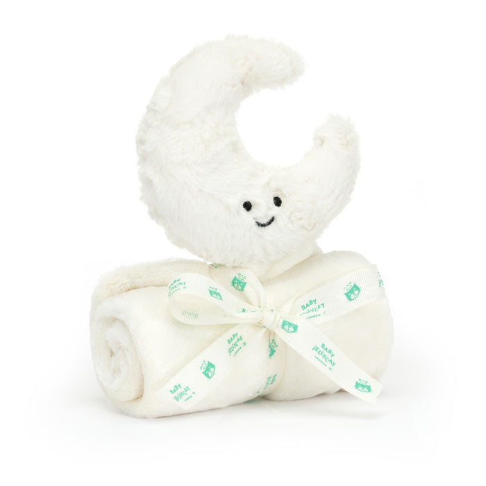 Plush toy shaped like a crescent moon sitting atop a rolled up baby blanket on a white background