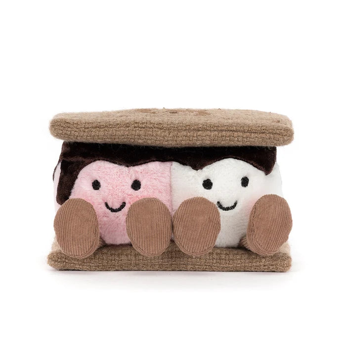 Plush toy resembling a s'more with a brown top and pink and white marshmallows on a white background
