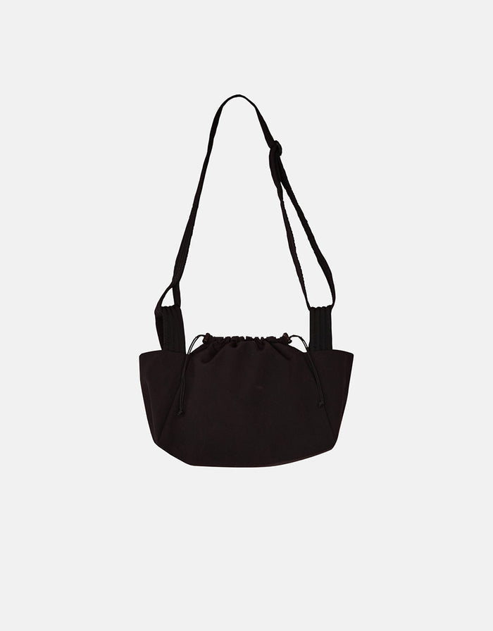 Minimalist black unisex mini bag with adjustable strap and drawstring closure, reflecting understated elegance and high-quality craftsmanship.