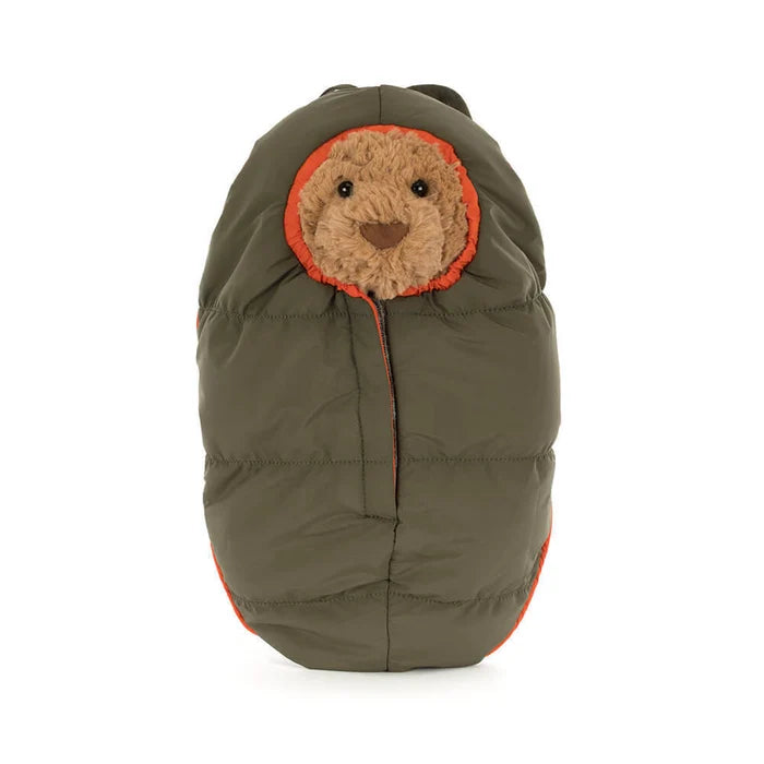Plush toy with bear face shown wrapped inside a sleeping bag on a white background