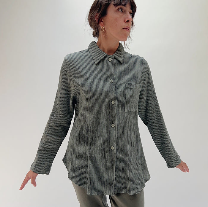 Front three-quarter view of model wearing Mill Valley Clothing Co olive boyfriend button-down shirt, showing point collar, chest pocket, and relaxed oversized fit