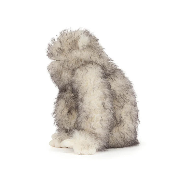 Plush toy resembling a yeti on a white background as seen from the side