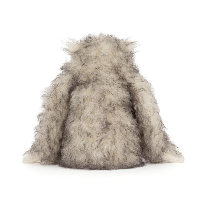 Plush toy resembling a yeti on a white background as seen from behind