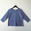 Blue and white striped shirt on a hanger against a white wall