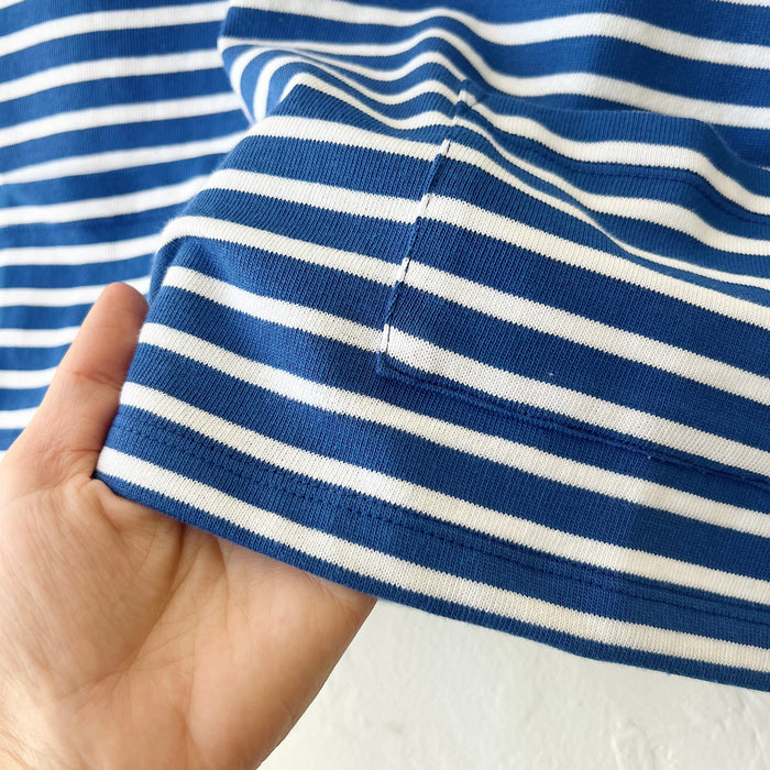 Close-up of a hand holding a blue and white striped fabric