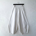 Pacific Cotton cream Oliver pant on hanger, front view showing elastic waistband, wide balloon-leg silhouette, patch panels at hem, and full length