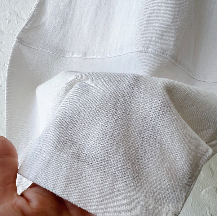 Close-up detail of Pacific Cotton cream Oliver pant hem, showing curved patch panel construction and cotton fabric texture