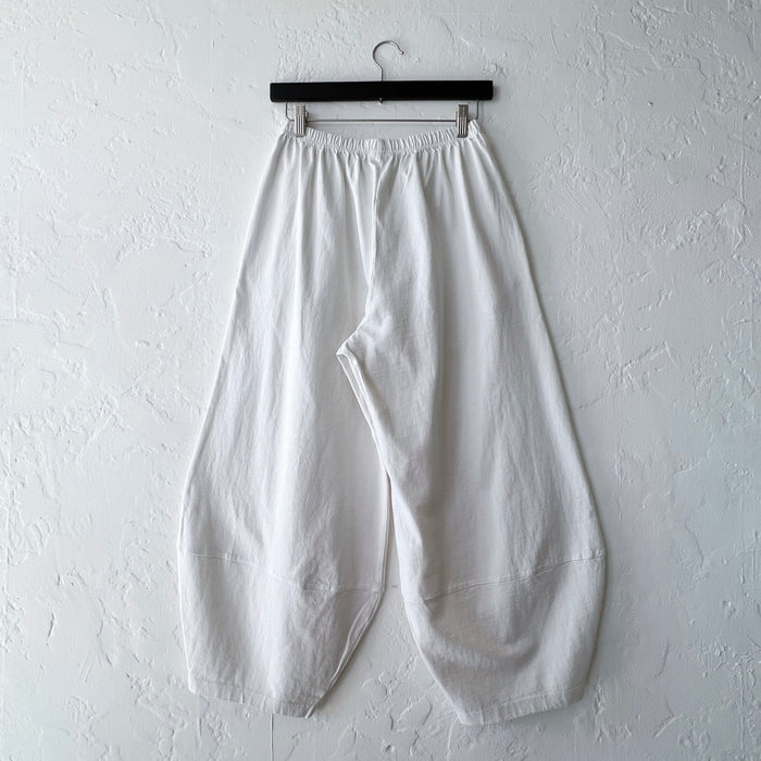 Pacific Cotton cream Oliver pant on hanger, back view showing elastic waistband, voluminous balloon-leg drape, and curved patch hem panels