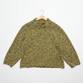Heather yellow knitted sweater on a hanger against a white wall