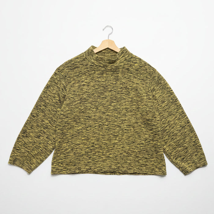 Heather yellow knitted sweater on a hanger against a white wall