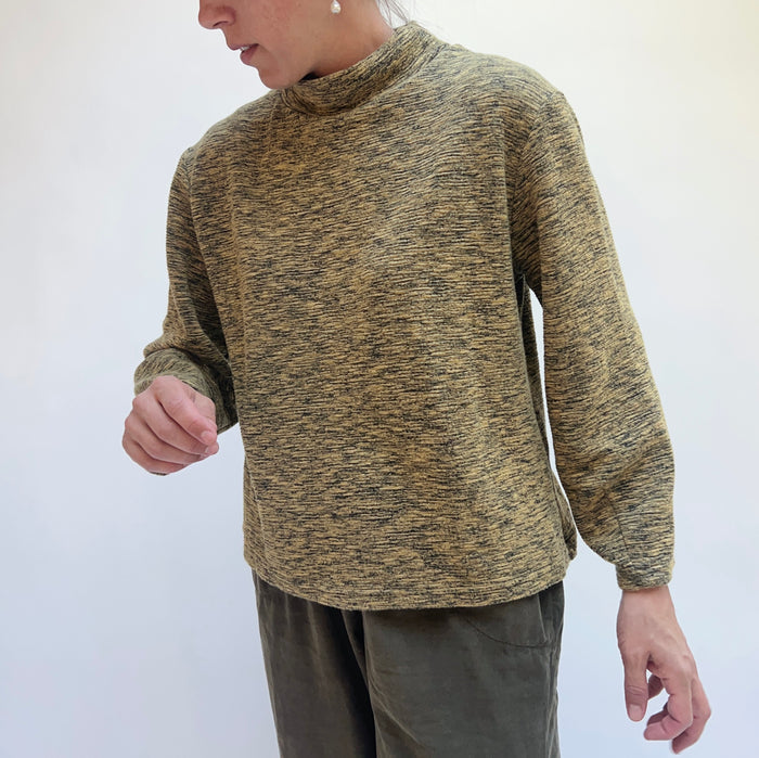 Person wearing a maroon sweater against a white background