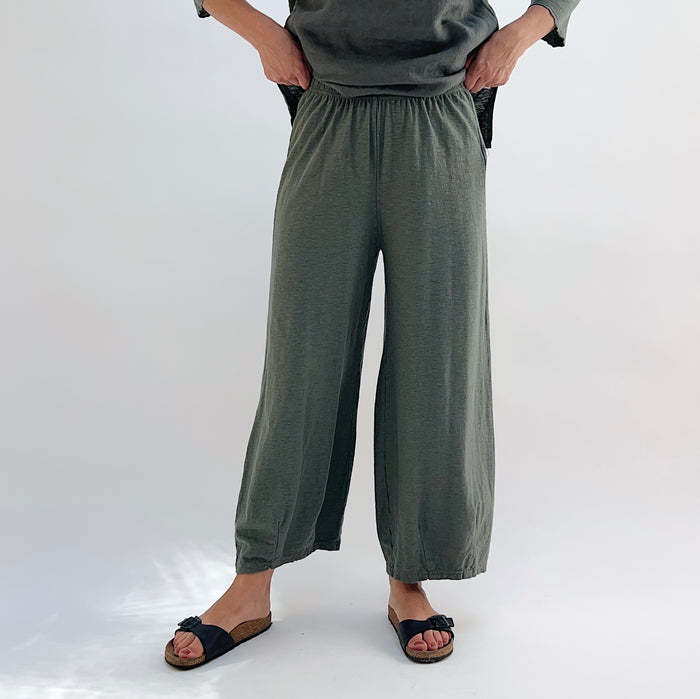 Person wearing green cropped pants on a plain background