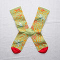Colorful socks with floral and dragonfly pattern on a light gray background
