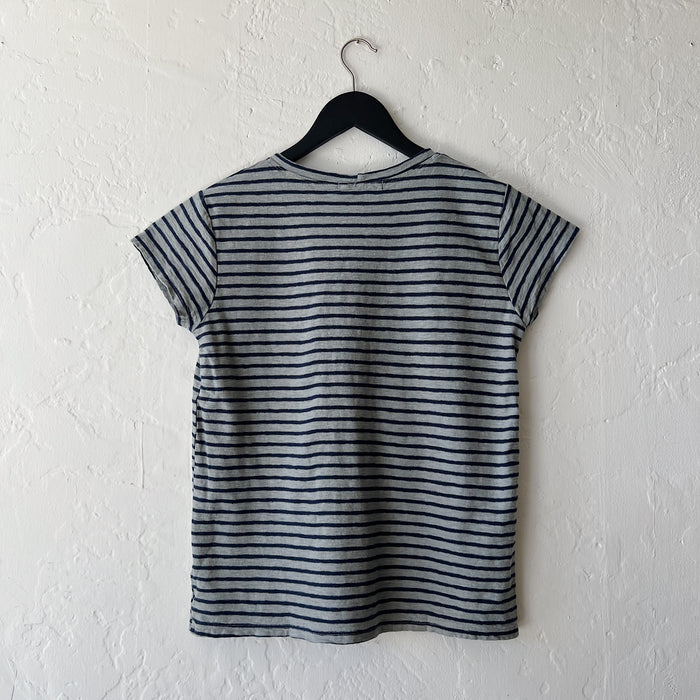 Striped t-shirt on a hanger against a white wall
