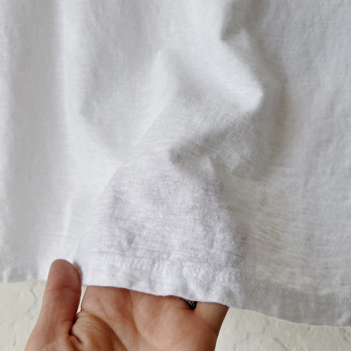 Close-up of a hand holding white fabric at the hem