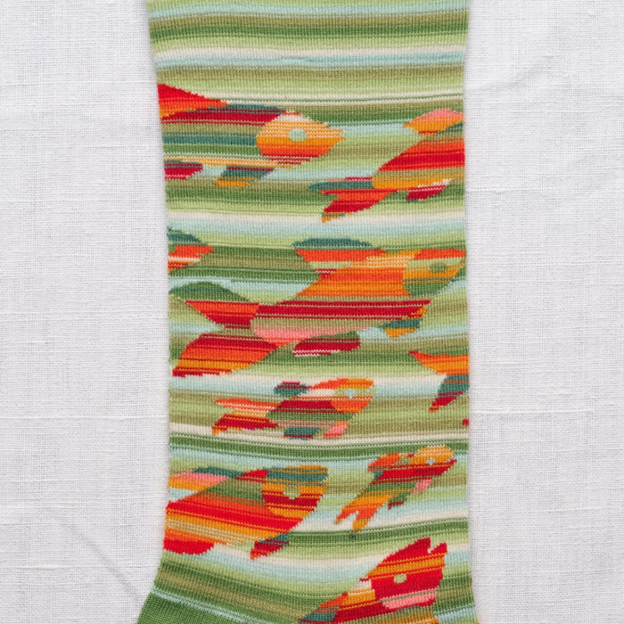 Close-up of the colorful woven fabric with abstract fish pattern on a white background