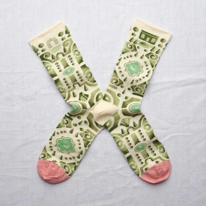 Pair of socks with green and pink pattern on a light gray background