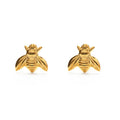 A pair of 14k gold over brass honey bee stud earrings on a white background.