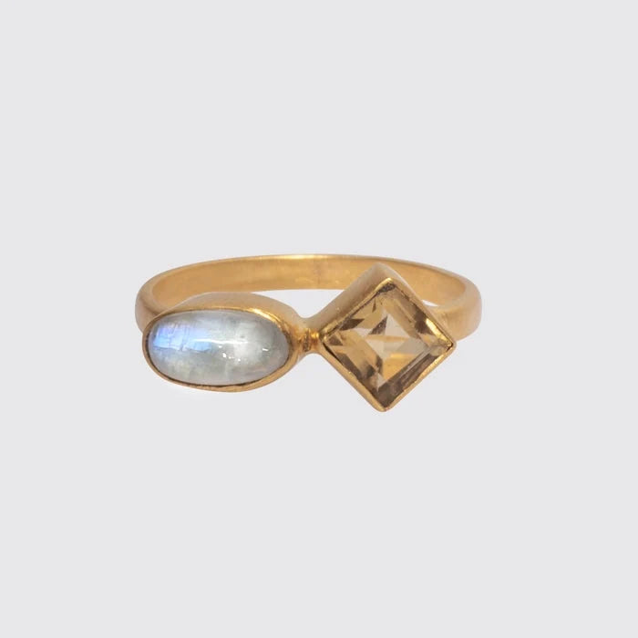 A gold stacking ring featuring an oval cabochon and a faceted square stone, both set in bezels, with a foil backing behind the stones.