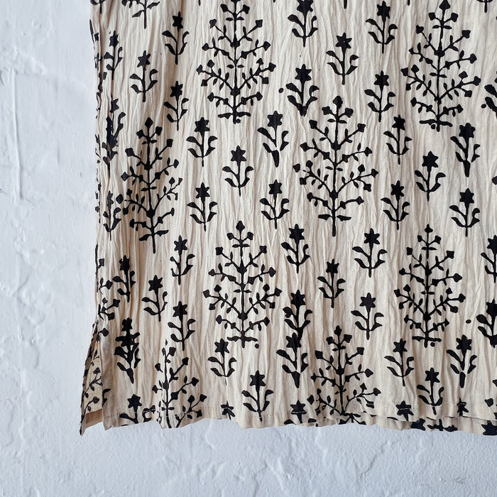 Fabric with black floral pattern on a beige background