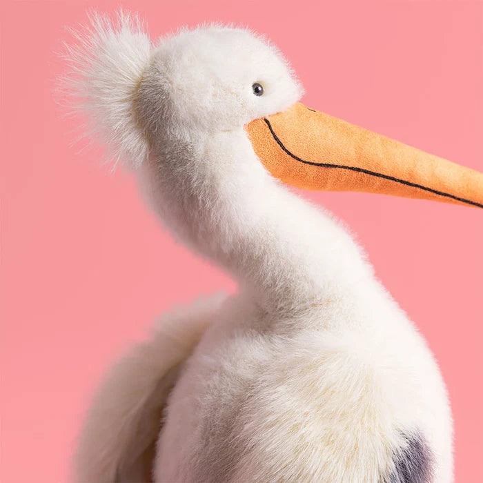 Plush toy pelican on a pink background
