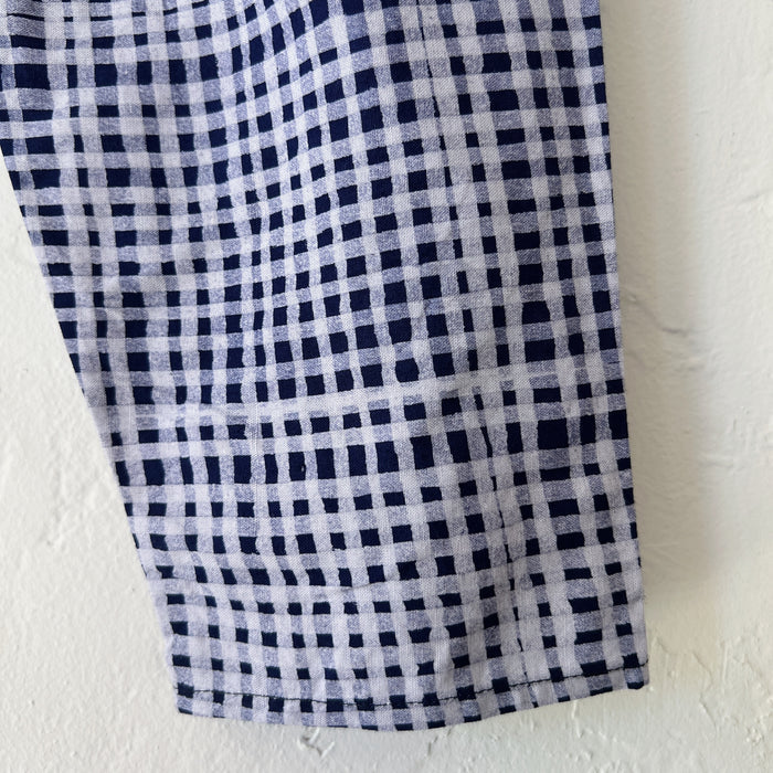 Close-up of hand-printed indigo gingham Batiki cotton fabric, showing the irregular hand-dyed check pattern and texture