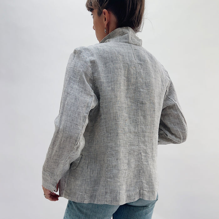 Back view of the Linen Blazer in Grey Pinstripe by Yuvita, showing the clean linen back, structured shoulders, and slightly cropped hem in grey pinstripe, styled with blue jeans
