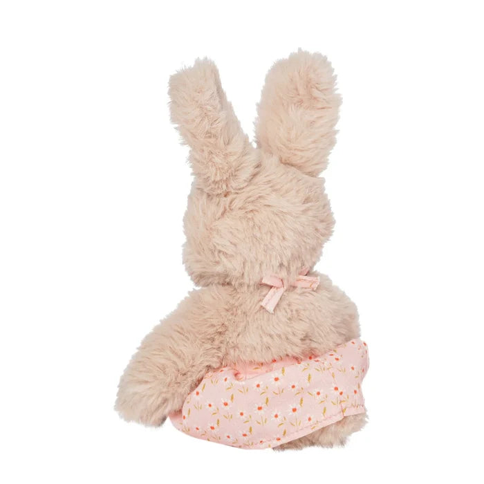 A rabbit stuffed toy in a pink floral apron shown from the back
