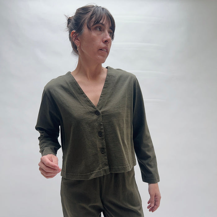 Woman wearing an olive green outfit against a plain background