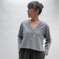 Woman wearing a gray long-sleeve cardigan with a v-neckline against a white background