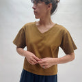 Woman wearing a brown shirt against a plain background