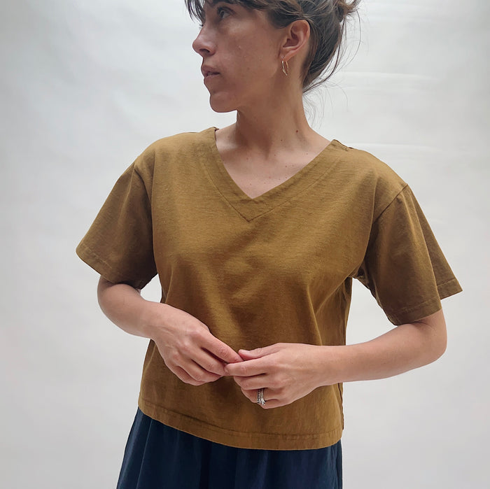 Woman wearing a brown shirt against a plain background