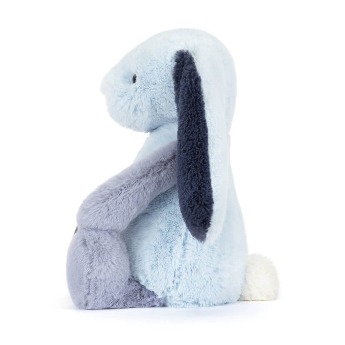 Plush toy rabbit with a light blue face and dark blue ears on a white background as seen from the side