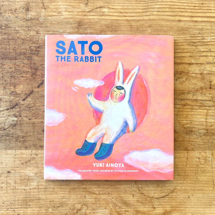 Book cover of 'Sato the Rabbit' by Yuki Ainoya on a wooden surface