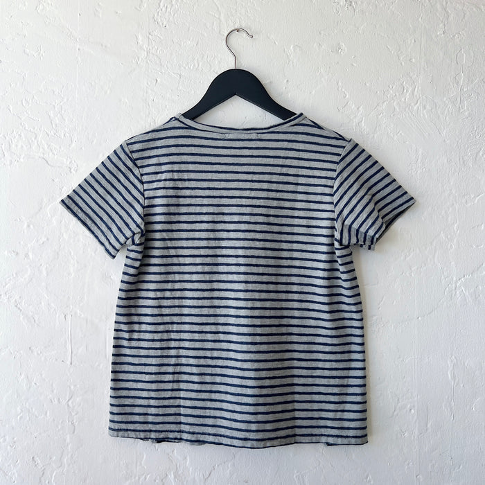 Striped t-shirt on a hanger against a white wall, viewed from the back