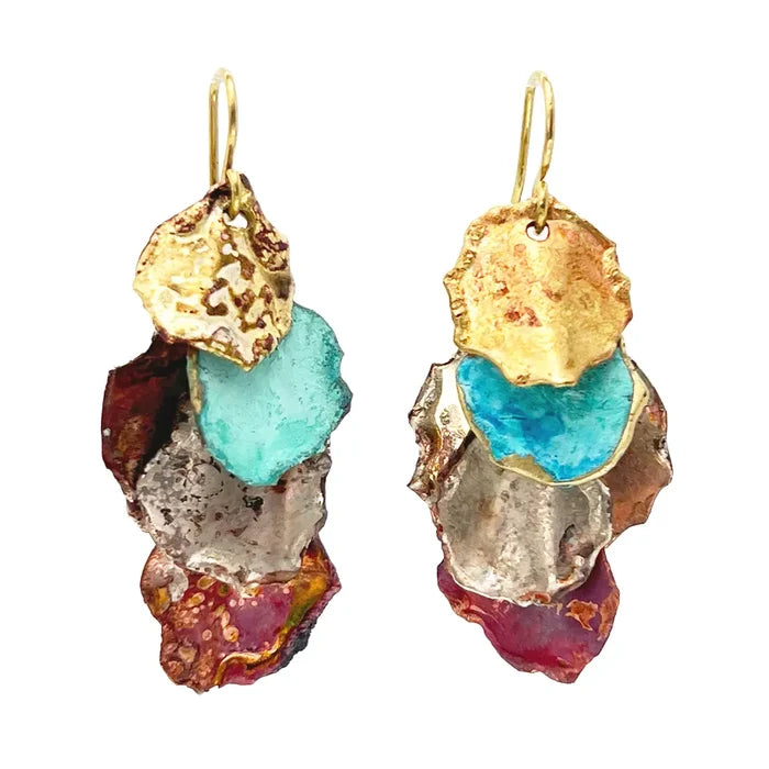 Pair of Sibilia Small Cometa Earrings in Mixed Canyon Patina, featuring three stacked irregular organic-shaped treated brass fragments in gold, turquoise, and red-brown mixed canyon patina, hanging from gold wire hooks, on a white background