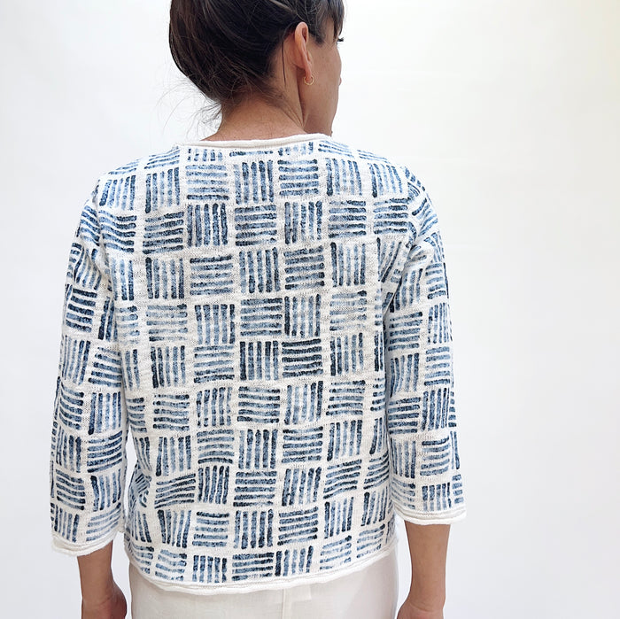 Back view of the Softly Stamped Pullover in White showing the all-over navy brushstroke grid print on white cotton knit and three-quarter sleeve length