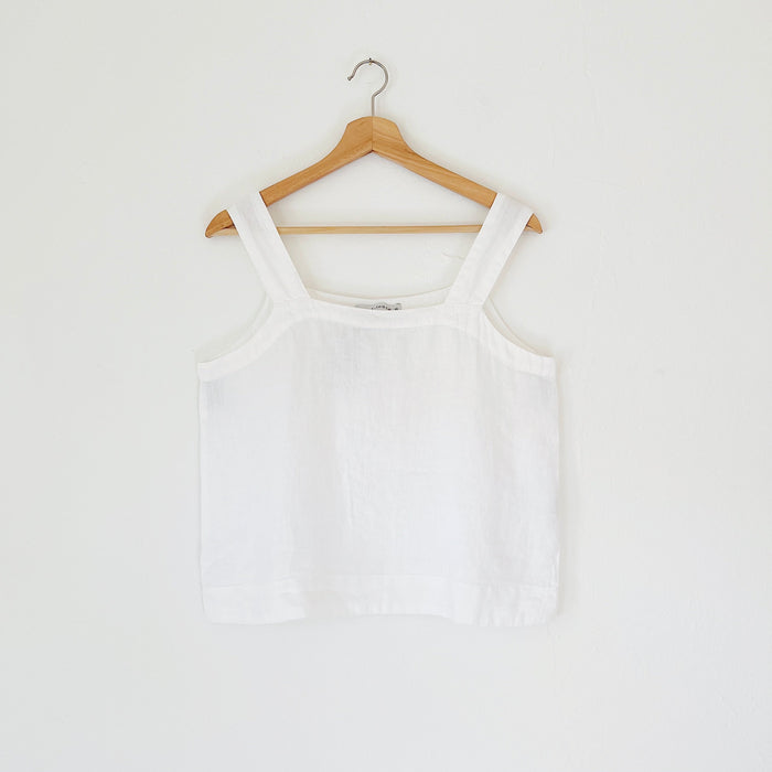 White tank top on a wooden hanger against a white background