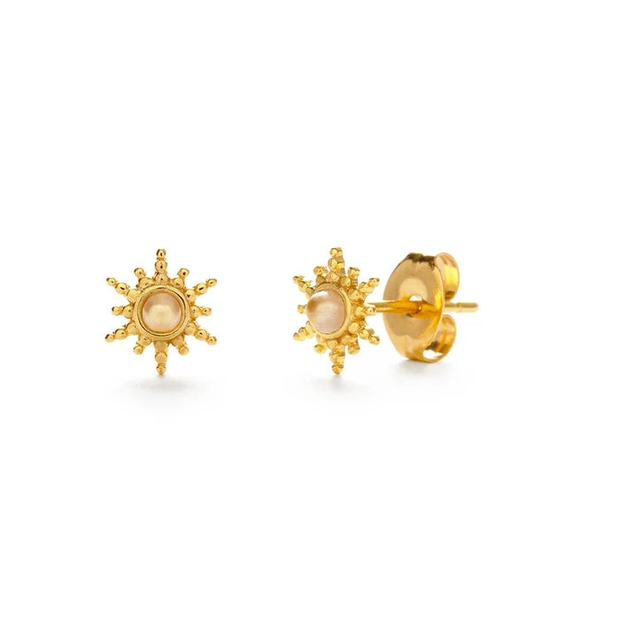Gold sun-shaped earrings with a central pearl on a white background