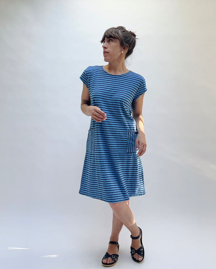 Woman wearing a blue striped dress against a white background