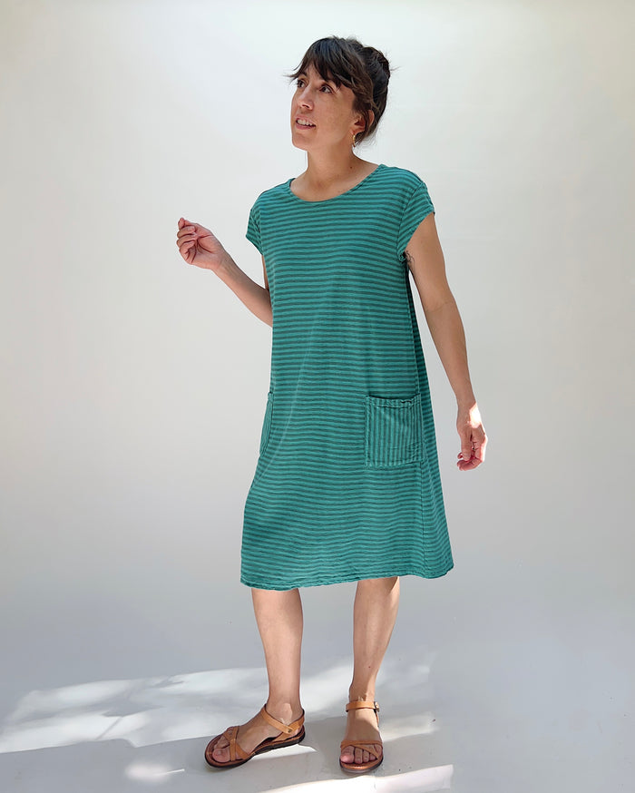 Woman wearing a green striped dress against a white background